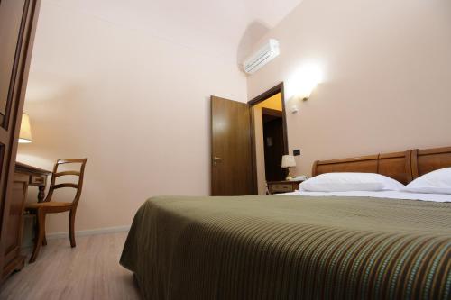 a bedroom with a bed and a desk and a chair at Il Giardinetto in Vercelli