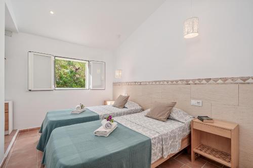 a bedroom with two beds and a window at Villa Abril in Santanyi