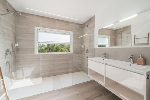 a bathroom with a tub and a sink and a mirror at Villa Abril in Santanyi