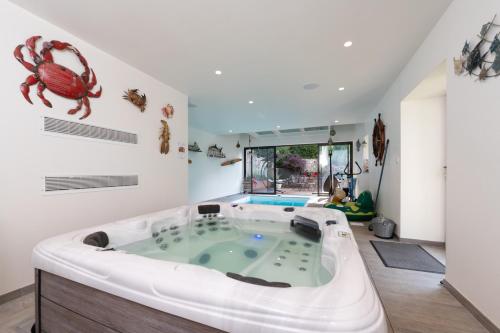 a large tub in a room with a crab on the wall at Ty Al Louarn - Piscine - Spa in Brech