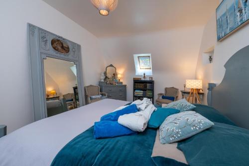 a bedroom with a large bed with blue pillows on it at Ty Al Louarn - Piscine - Spa in Brech