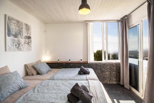 a bedroom with two beds and a large window at Amanecer 4 in Mácher