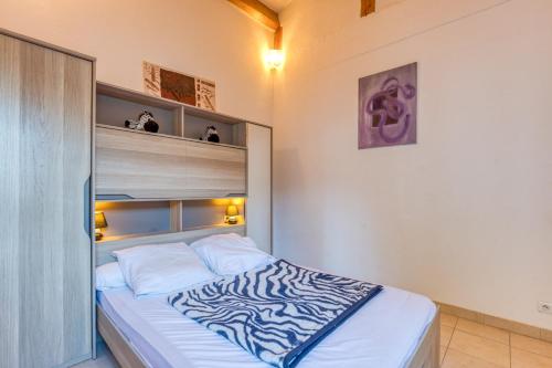 a zebra print bed in a small bedroom at La Madrague St Vincent Apt A in Le Grau-dʼAgde
