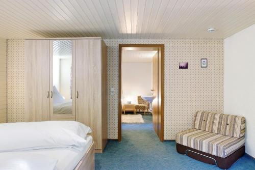 a hotel room with a bed and a chair at Haus Steinhäusle - 2 fewos in Vöhrenbach