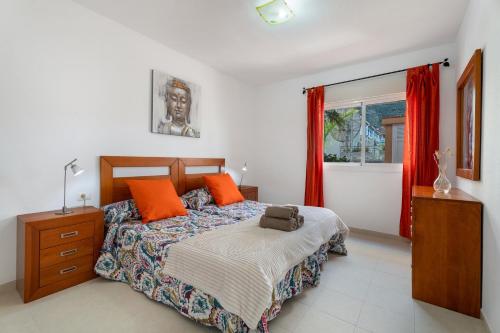 a bedroom with a bed with orange pillows at Chasna Sunset in Adeje
