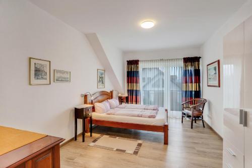 a bedroom with a bed and a chair in a room at Ferienwohnung Familie Arnhofer in Waal