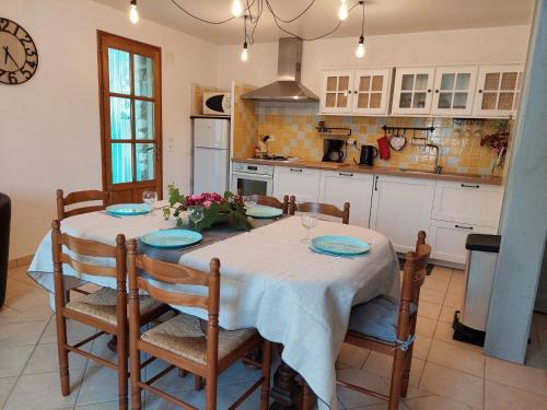 a kitchen with a table and some chairs and a kitchen with a tableablish at Le Vieil Olivier in Sahune