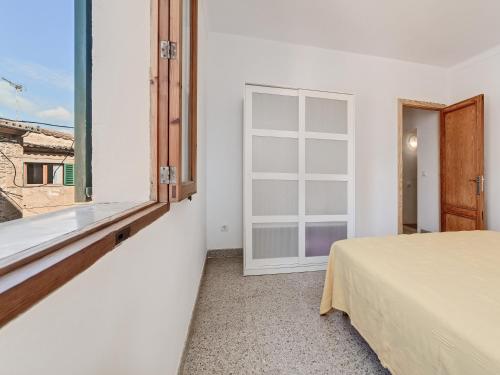 a bedroom with a bed and a large window at Casa Convent in Alcudia