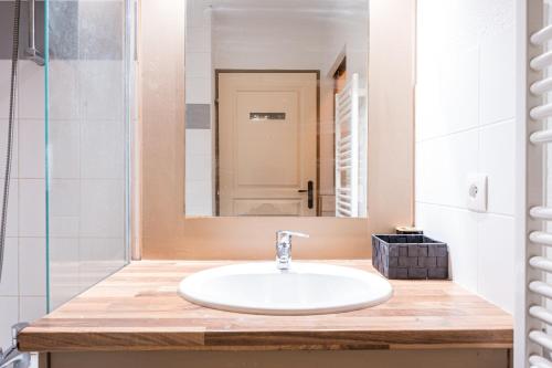 a bathroom with a sink and a mirror at Appartement spa fleures d'Orelle in Orelle