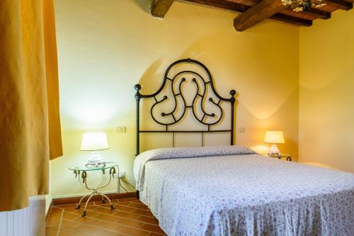a bedroom with a bed and two tables with lamps at Il Cancellone - Grillo in Montiano