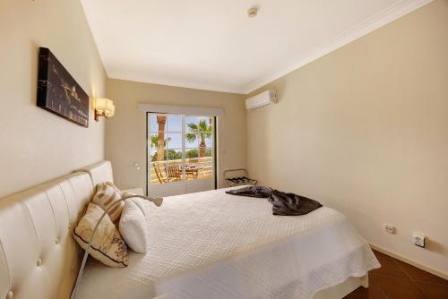 a bedroom with a white bed and a window at Sol do Atlântico in Portimão