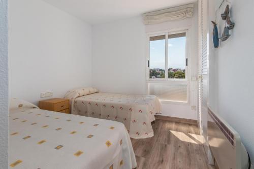two beds in a room with a window at La Escala in L'Escala