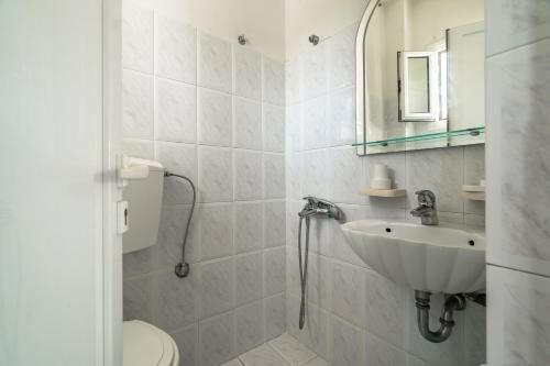 a white bathroom with a sink and a toilet at Angela partial sea view 6 in Kefallonia