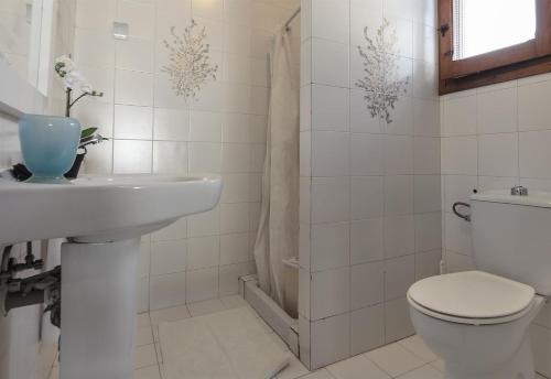 a white bathroom with a toilet and a sink at Vista Bahía in Moraira