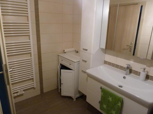 a white bathroom with a sink and a mirror at Haus Bergblick 1 in Utzmemmingen