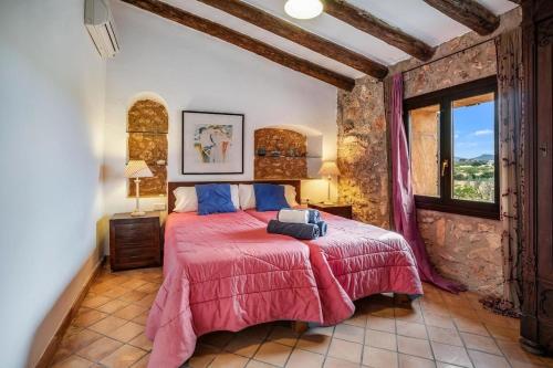 a bedroom with a large bed with a red comforter at Finca Can Moleta in Cala Mendia