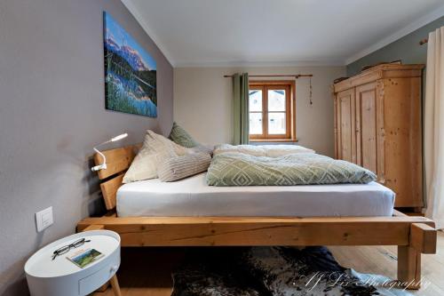 a bedroom with a bed with a wooden bench at Ferienwohnung Bienennest in Mittenwald