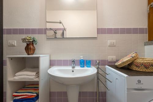 a bathroom with a sink and a mirror at Centralissimo Charlie Beach in Castelsardo