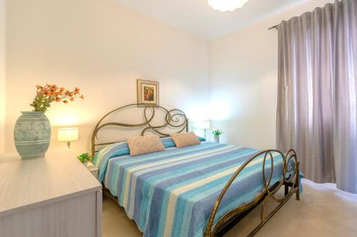 a bedroom with a bed and a vase on a table at Centralissimo Charlie Beach in Castelsardo