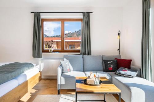 a living room with a couch and a bed at Fewo Am Steinbach - Stoaboch in Reit im Winkl