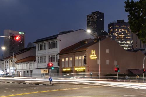 a city street at night with traffic lights and buildings at Heritage Collection on Victoria - Mobile App Check-In in Singapore