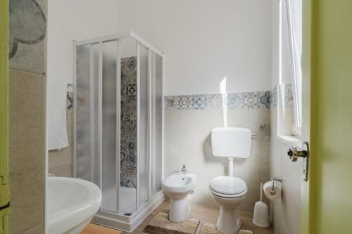 a white bathroom with a toilet and a shower at Disiu Case Vacanza - Balestrate in Balestrate
