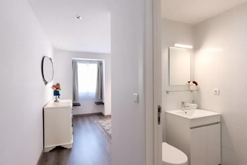 a white bathroom with a sink and a mirror at Casa Douro Janja in Armamar