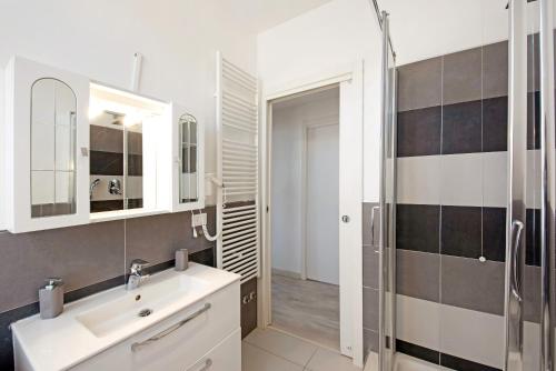 a white bathroom with a sink and a shower at Bilocale Mezzano in centro in Varazze