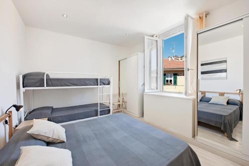 a bedroom with two bunk beds and a window at Bilocale Mezzano in centro in Varazze