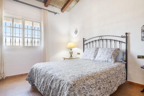 a bedroom with a large bed and a window at Casa Altamar in Barbate