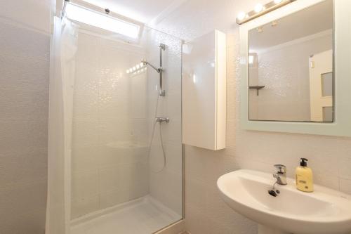 a white bathroom with a shower and a sink at Casa Chloe in Nerja
