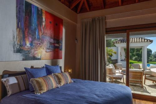 a bedroom with a blue bed and a patio at Villa Lara in Benalup Casas Viejas