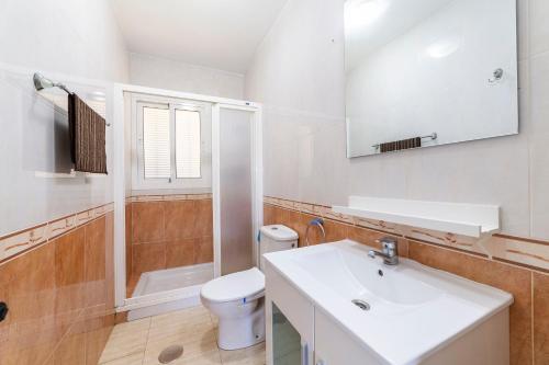 a white bathroom with a sink and a toilet at Gaviotas 4 in Aguadulce