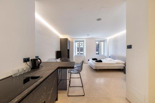 a kitchen with a counter and a living room with a bed at App 203 Palazzo Cavour in Bolzano