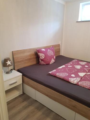 a small bedroom with a bed and a night stand at Lila Pause in Ellweiler