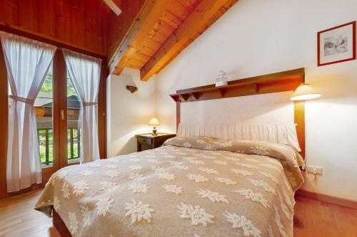 a bedroom with a bed and a large window at The Waterfall Chalet in La Salle