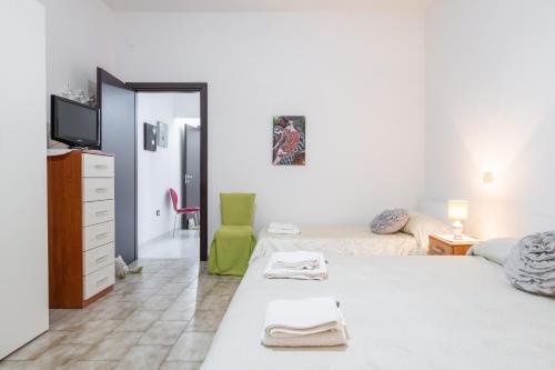a bedroom with two beds and a tv and a mirror at Gerani Rossi Appartamento in Villa San Pietro