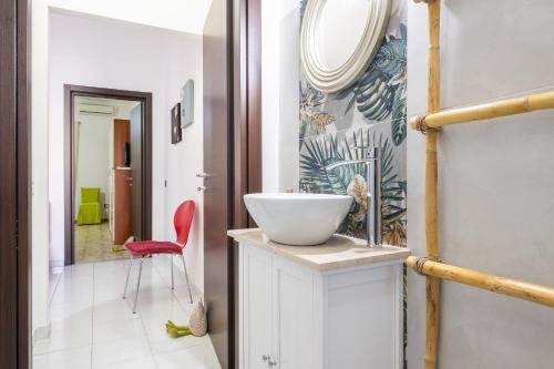 a bathroom with a white sink and a red chair at Gerani Rossi Appartamento in Villa San Pietro
