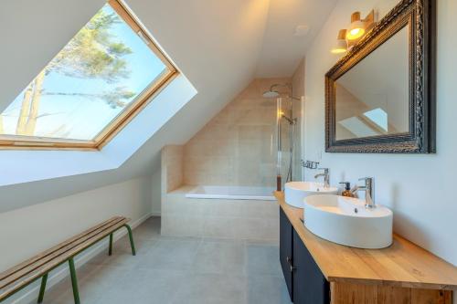 a bathroom with two sinks and a large window at Maison Stoubenn in Kerlouan
