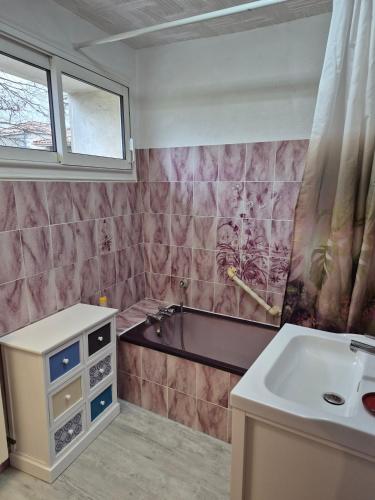 a bathroom with a sink and a bath tub at Mamie Krema in Boresse-et-Martron