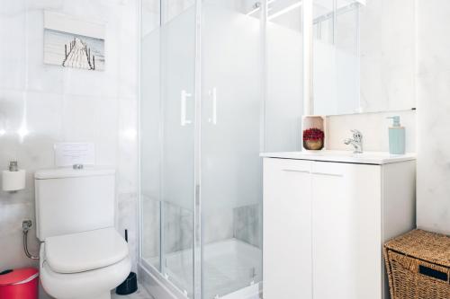 a white bathroom with a toilet and a shower at Duplex Seville-Historic Center in Seville