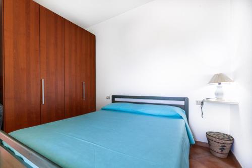 a bedroom with a bed and a wooden cabinet at I girasoli in Villasimius