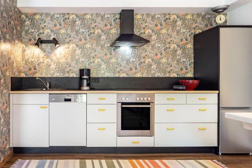 a kitchen with white cabinets and a floral wallpaper at Krottenhill 2 ¼ in Ingenried