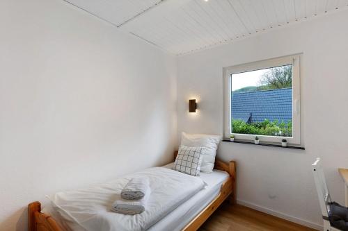 a small bedroom with a bed and a window at Sauerland Oase in Meschede