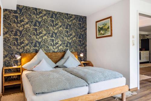 a bedroom with a large bed with a wallpaper at Krottenhill 2 ¼ in Ingenried