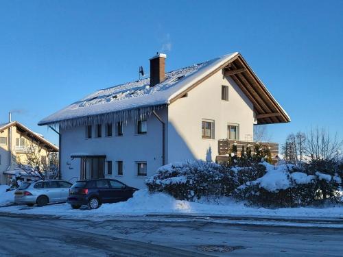 a white house with a snow covered roof at Haus Hanni in Höchenschwand