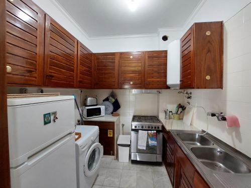 a small kitchen with wooden cabinets and a white refrigerator at Estoril Sea You in Estoril
