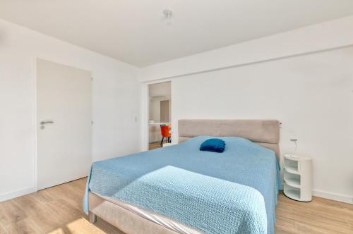 a white bedroom with a blue bed in it at Appartement Port Lin proche Océan in Le Croisic
