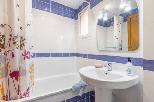 a blue and white bathroom with a sink and a tub at Edificio Menorca in Balcon del Mar