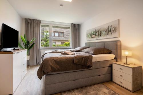 a bedroom with a bed and a tv and a window at Kleines Glück in Delmenhorst